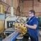 Two workers wearing blue uniform inspecting hydraulic cylinders